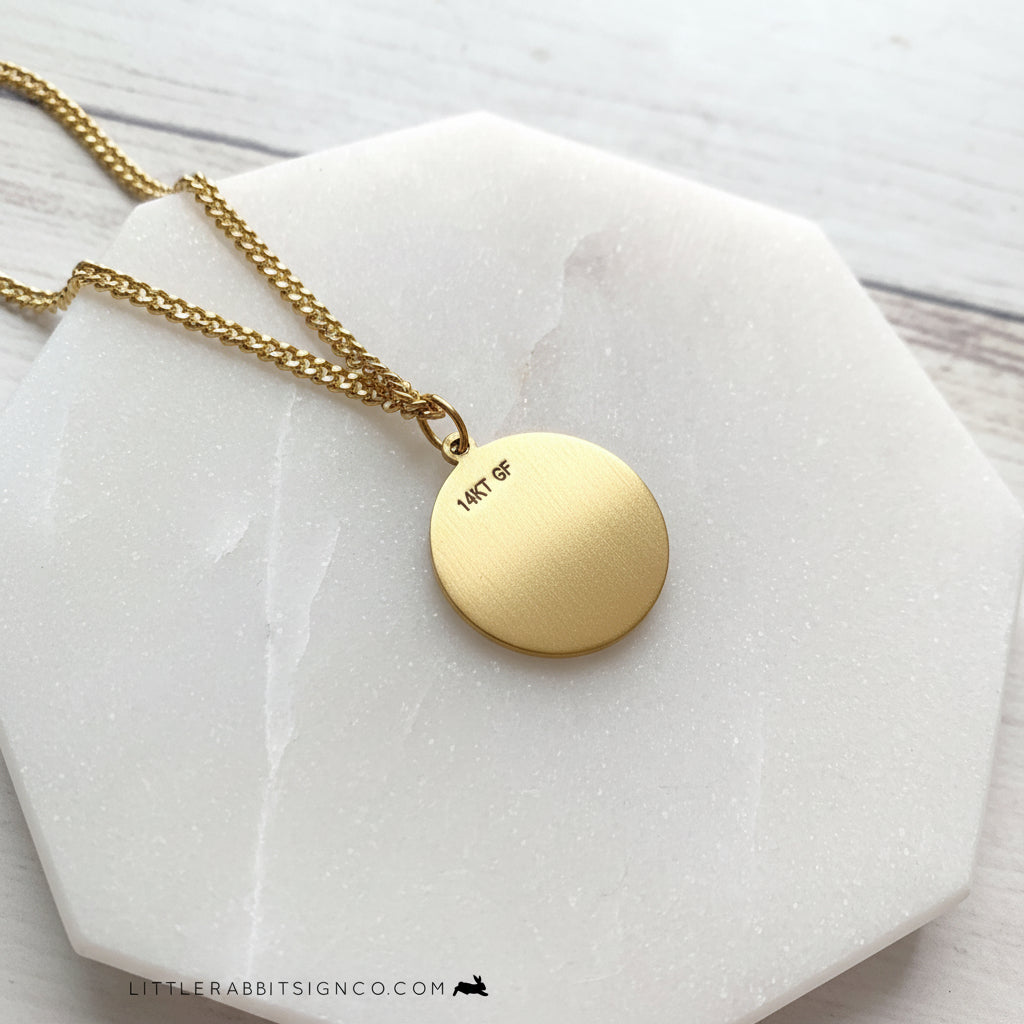 Back of the Men's Saint Dymphna 14kt gold filled necklace on a white background. 