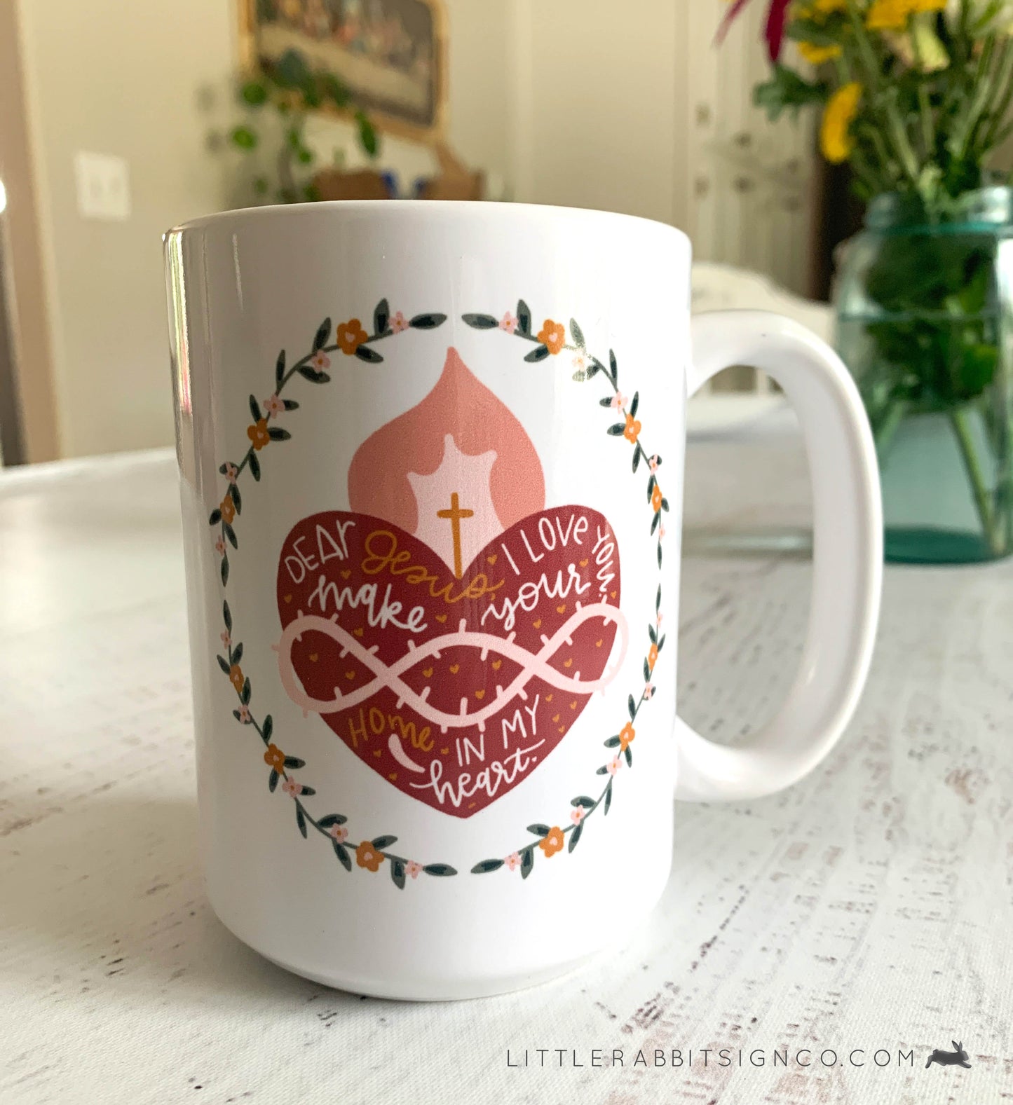 Sacred Heart of Jesus Coffee Mug with a Hand drawn illustration of Jesus' Sacred Heart with a white glossy background. Text reads "Dear Jesus, I love you. Make your home in my heart."