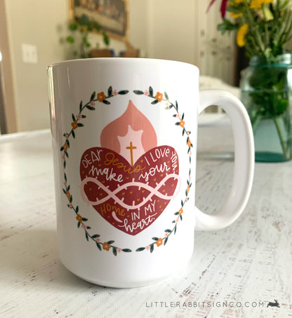 Sacred Heart of Jesus Coffee Mug with a Hand drawn illustration of Jesus' Sacred Heart with a white glossy background. Text reads "Dear Jesus, I love you. Make your home in my heart."