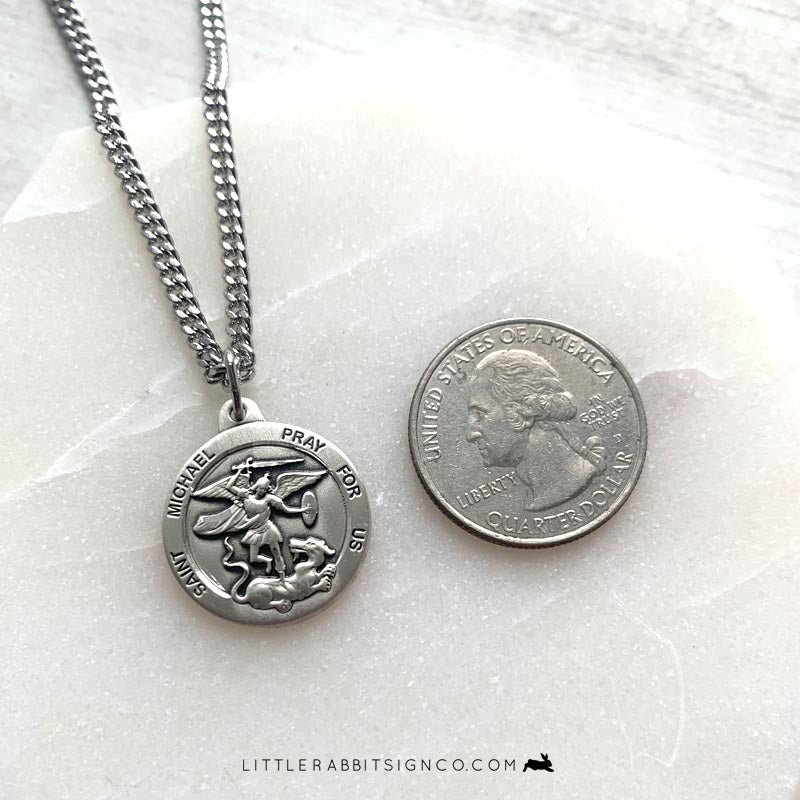 Saint Michael Archangel sterling silver necklace next to quarter for size reference