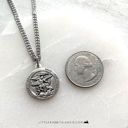 Saint Michael Archangel sterling silver necklace next to quarter for size reference