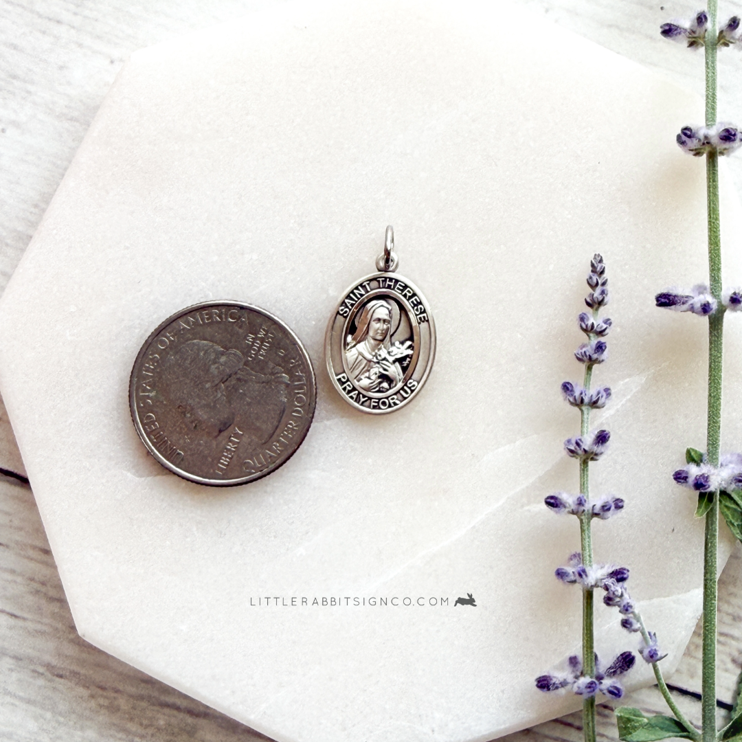 Sterling silver Saint Thérèse of Lisieux necklace next to quarter for size reference — 3/4 inch Catholic medal