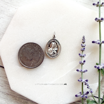 Sterling silver Saint Thérèse of Lisieux necklace next to quarter for size reference — 3/4 inch Catholic medal