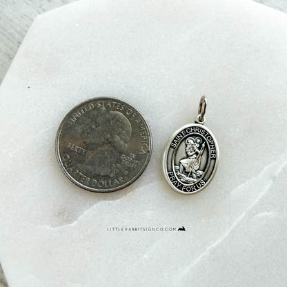 Sterling silver Saint Christopher necklace next to quarter for size reference — 3/4 inch Catholic medal